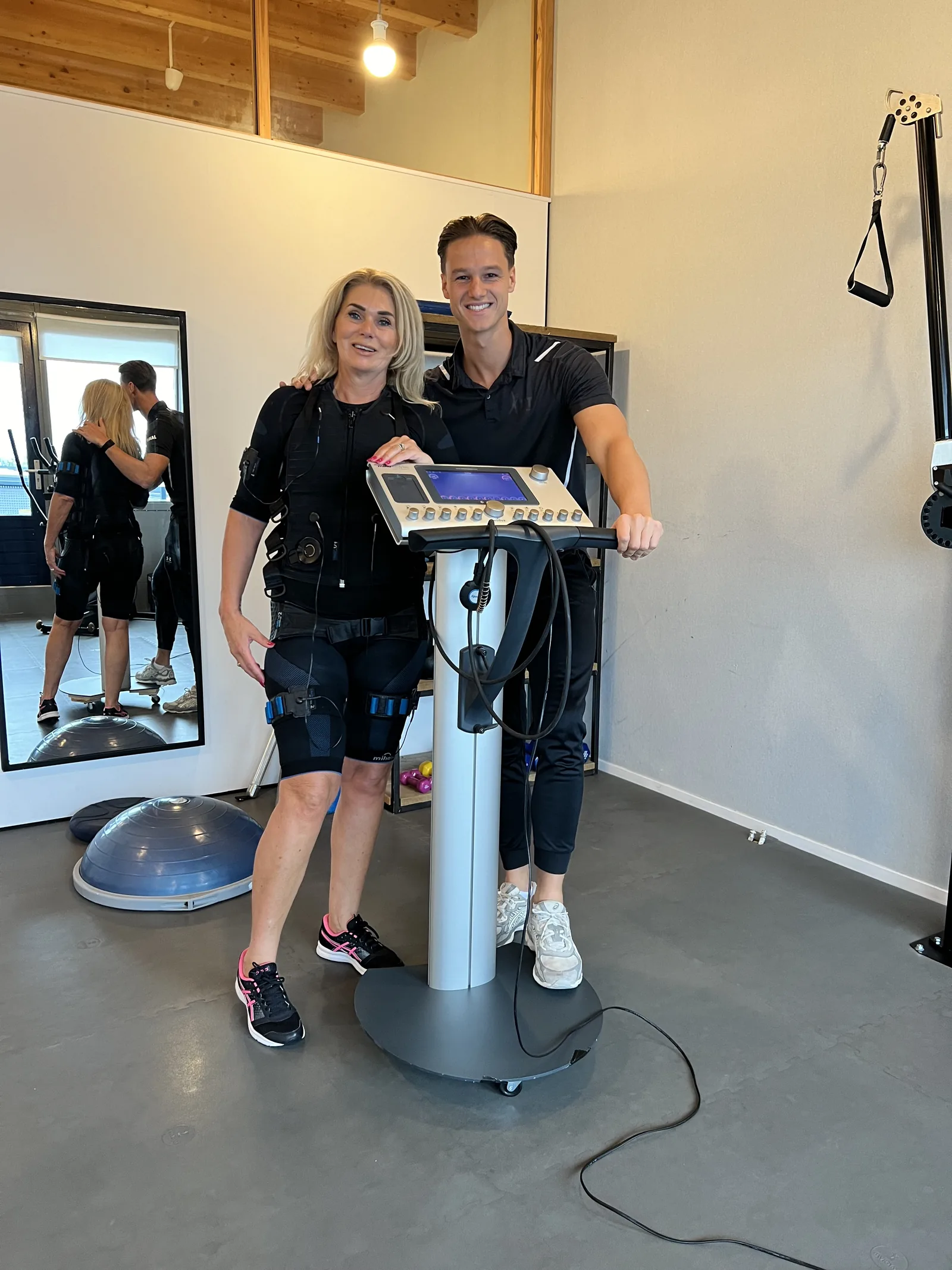 Stan begeleidt een klant in EMS-pak bij het Bodytec-station van JPT