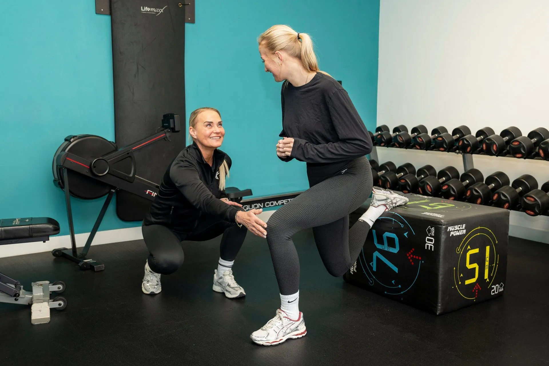 Twee dames trainen samen met dumbbells tijdens een training bij JPT