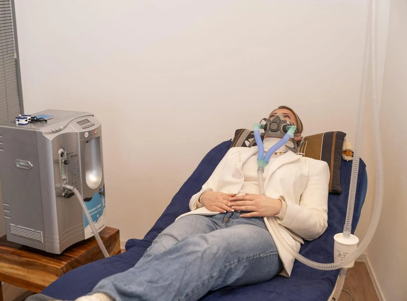 Vrouw traint liggend met een hoogtetrainingsmasker tijdens hypoxietherapie