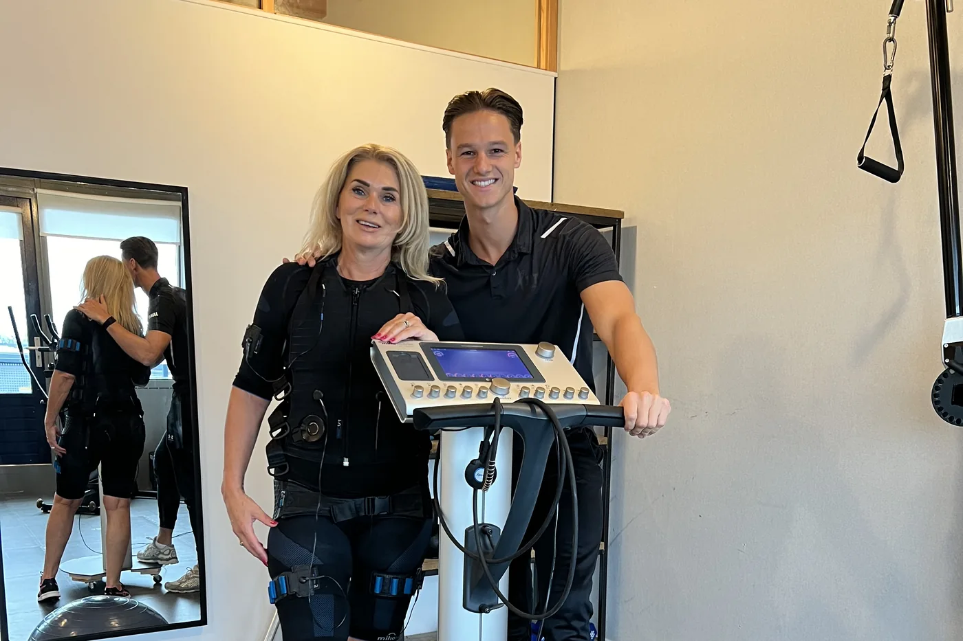 Cliënt traint in een EMS-Bodytec-pak onder begeleiding van een coach