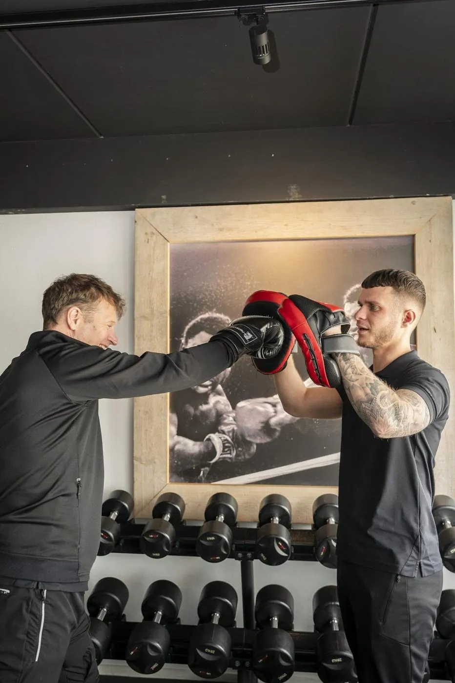 Personal trainer begeleidt een cliënt tijdens een krachtoefening in de privé trainingsruimte van JPT